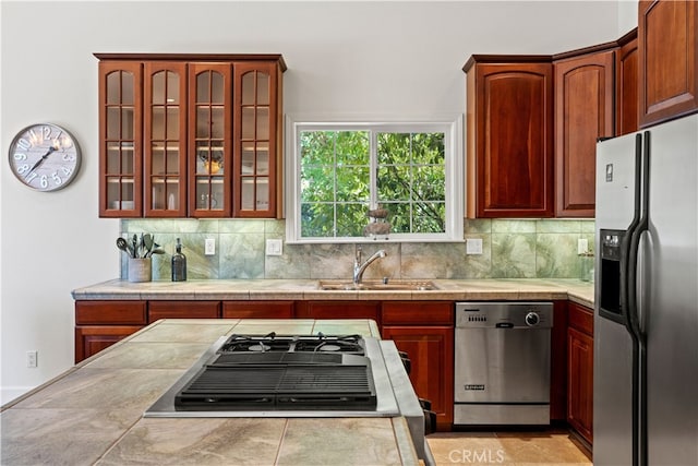 kitchen featuring decorative backsplash, sink, and stainless steel appliances