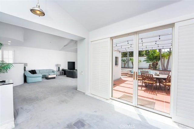 interior space featuring concrete flooring, a healthy amount of sunlight, and lofted ceiling