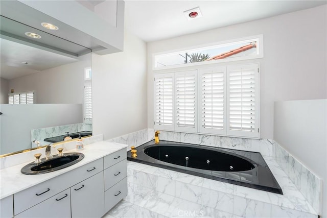 bathroom featuring vanity and a relaxing tiled tub