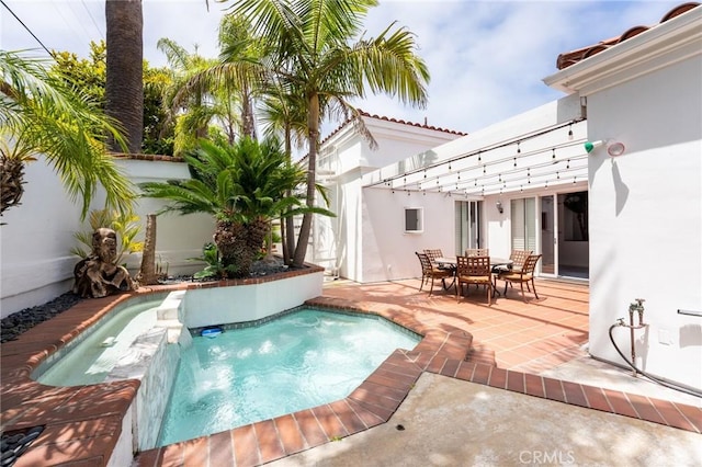 view of swimming pool featuring a patio and a hot tub