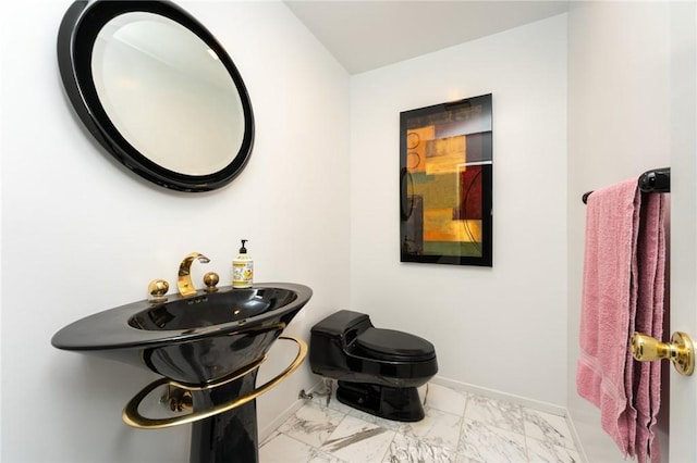 bathroom with baseboards, marble finish floor, and toilet
