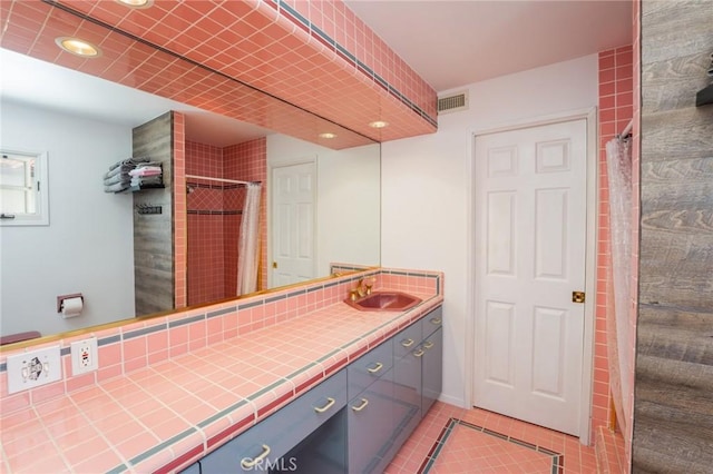 bathroom with a shower with curtain, vanity, and tile patterned floors