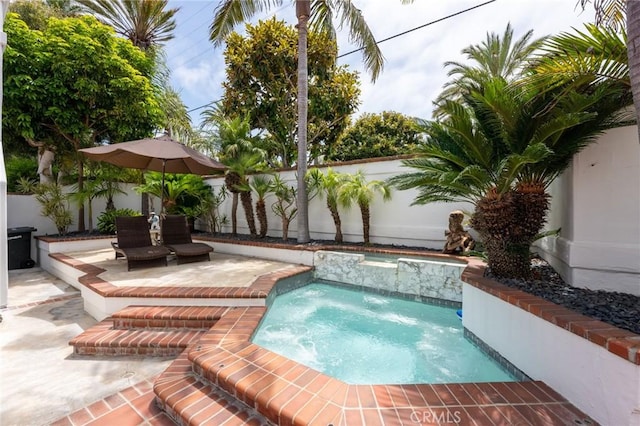 view of pool with a fenced backyard, an in ground hot tub, and a patio area
