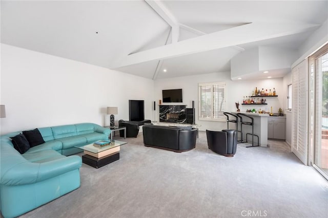 living room featuring light colored carpet, bar area, and vaulted ceiling with beams