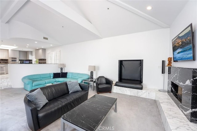 living room with vaulted ceiling with beams and a premium fireplace