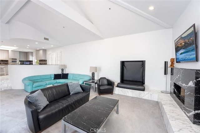 living area featuring a high end fireplace, vaulted ceiling with beams, recessed lighting, and visible vents
