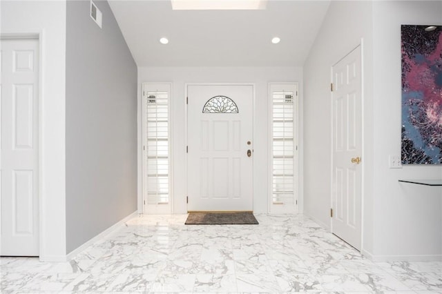 foyer entrance with baseboards, visible vents, and marble finish floor