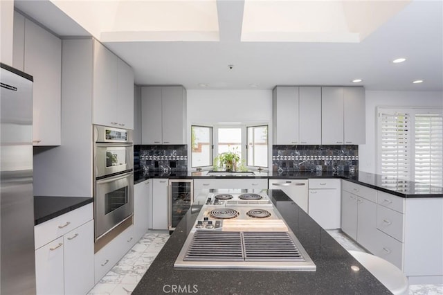 kitchen featuring appliances with stainless steel finishes, backsplash, and wine cooler