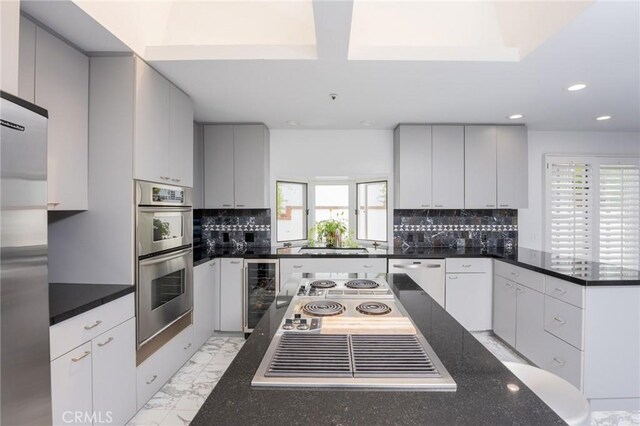 kitchen with appliances with stainless steel finishes, beverage cooler, marble finish floor, recessed lighting, and decorative backsplash