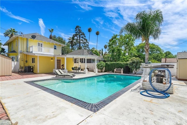 view of swimming pool featuring central air condition unit and a patio area