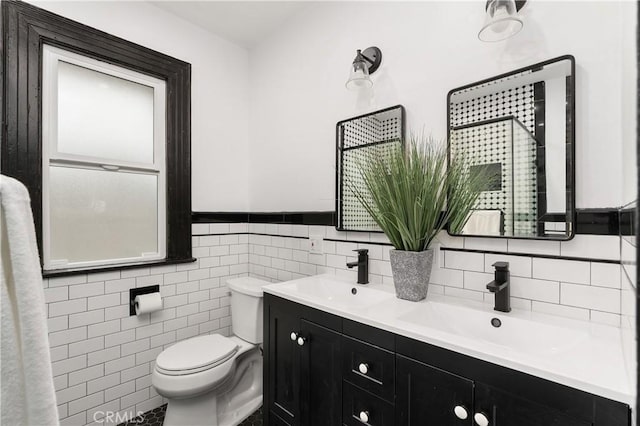 bathroom with vanity, toilet, and tile walls