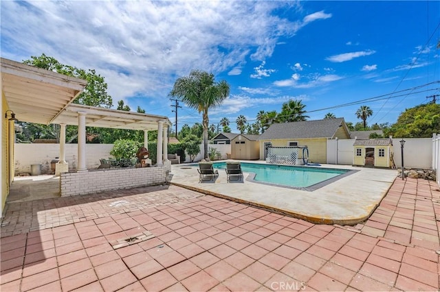 view of pool with a storage unit, a patio area, and a pergola