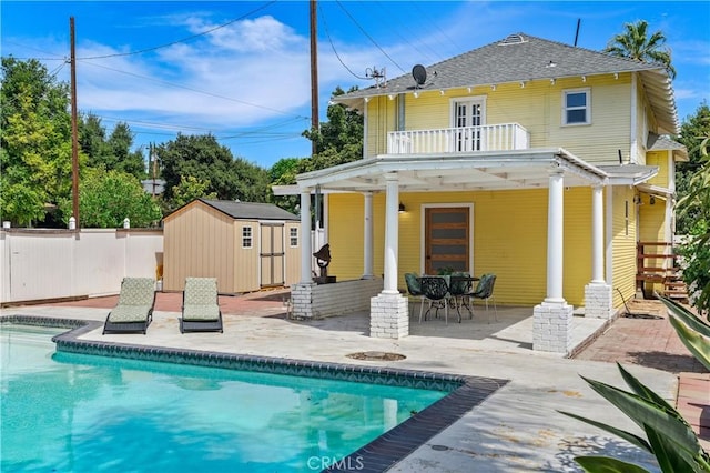 back of house with a storage unit, a balcony, and a patio