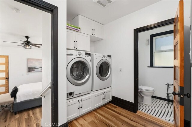 washroom featuring ceiling fan, light hardwood / wood-style floors, cabinets, and separate washer and dryer