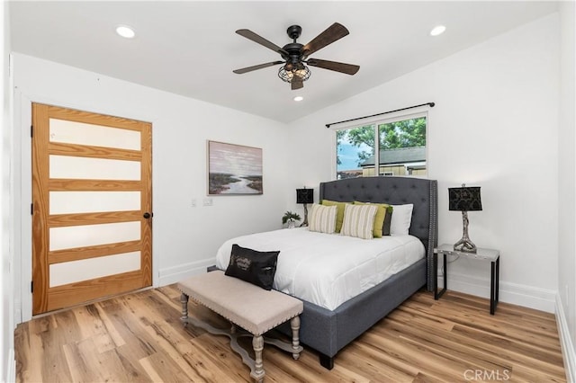 bedroom with ceiling fan, vaulted ceiling, and light hardwood / wood-style flooring