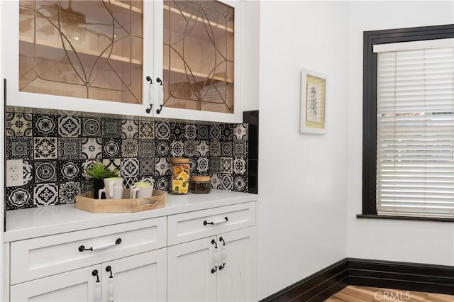 bar featuring white cabinets and tasteful backsplash