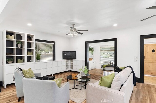 living room with a wealth of natural light, ceiling fan, and light hardwood / wood-style floors