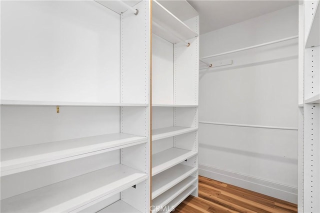 walk in closet with light hardwood / wood-style floors