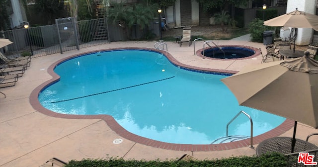 view of pool with a community hot tub and a patio area