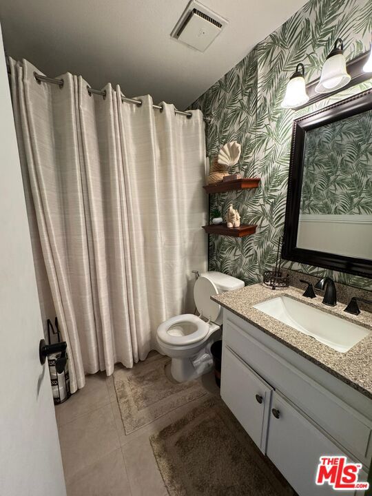 bathroom featuring toilet, vanity, and tile patterned floors