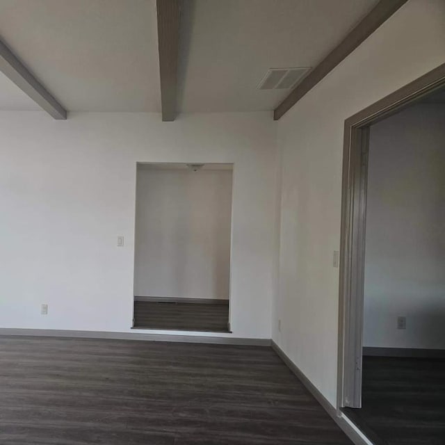 unfurnished room with dark hardwood / wood-style flooring and beamed ceiling