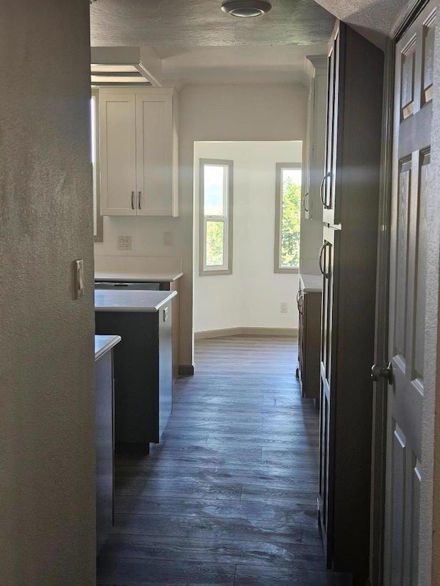 kitchen with dark hardwood / wood-style flooring, white cabinetry, and a textured ceiling