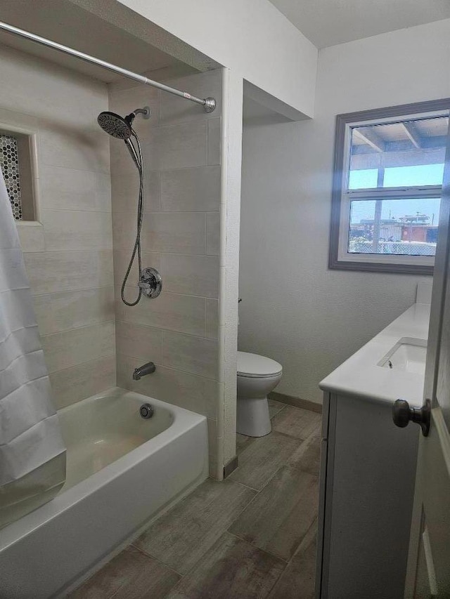 full bathroom with toilet, vanity, and tiled shower / bath