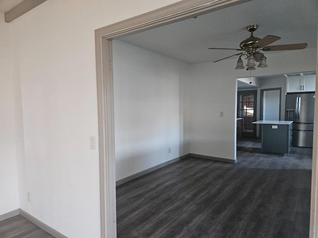 unfurnished living room featuring ceiling fan, dark hardwood / wood-style flooring, and beamed ceiling