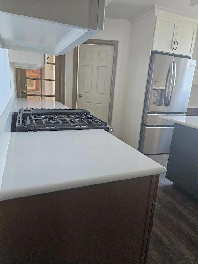 kitchen with exhaust hood, dark hardwood / wood-style floors, white cabinetry, stainless steel fridge with ice dispenser, and range