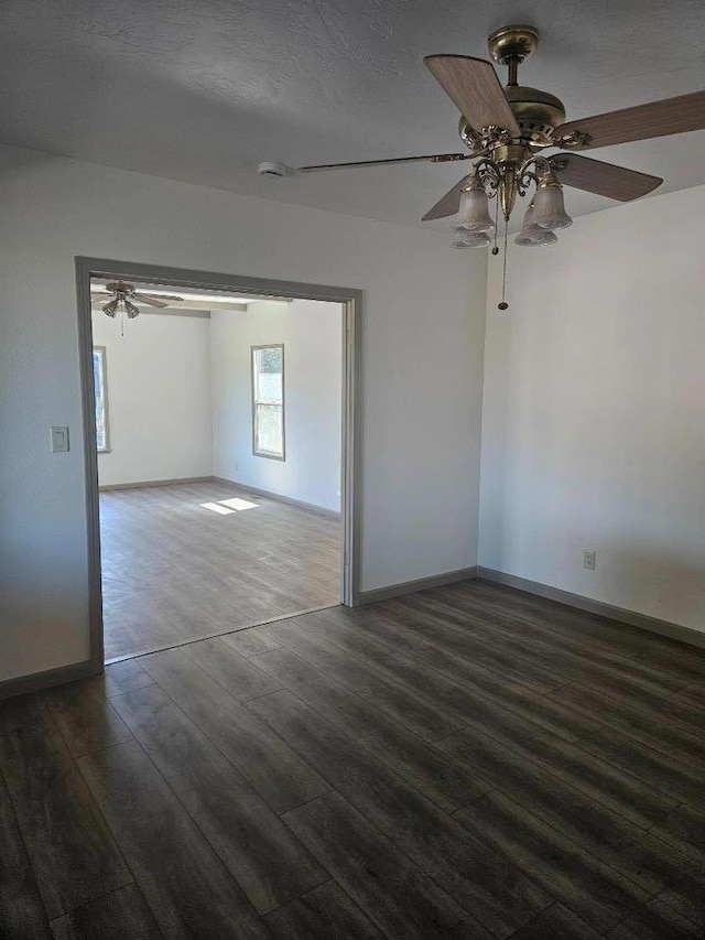 empty room with a textured ceiling, ceiling fan, and dark hardwood / wood-style flooring