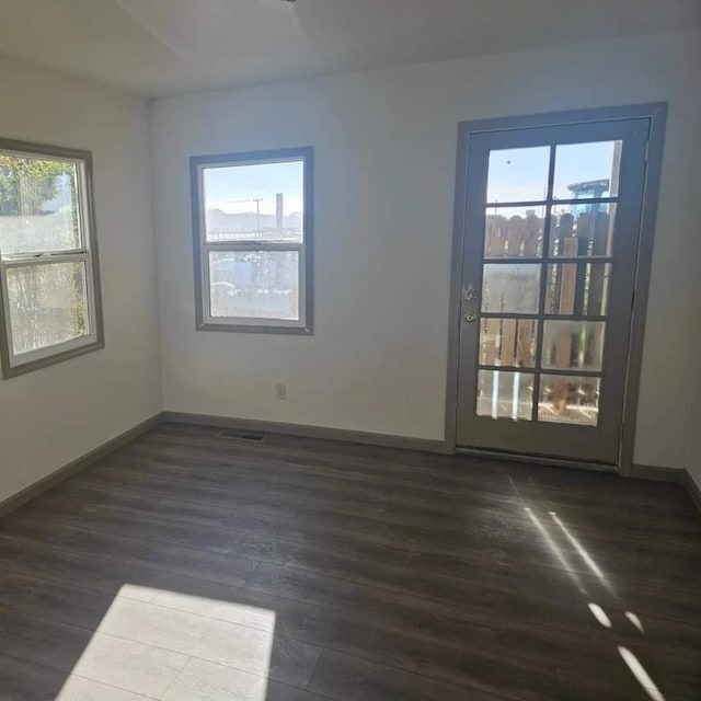 empty room with dark hardwood / wood-style flooring