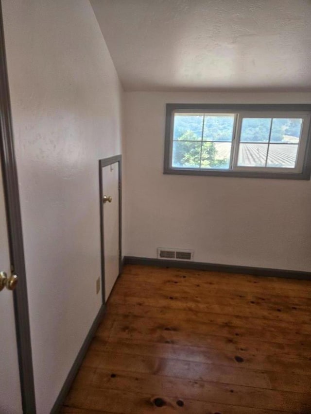 unfurnished room with dark hardwood / wood-style flooring