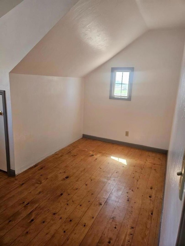 bonus room featuring lofted ceiling and light hardwood / wood-style flooring