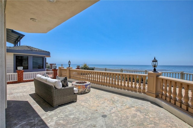 view of patio with a fire pit and a water view