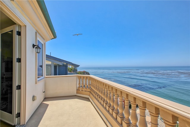 balcony featuring a view of the beach and a water view