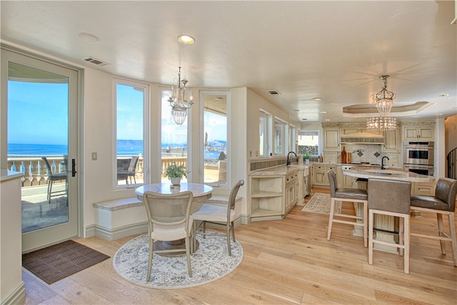 dining area featuring a water view, a chandelier, and a wealth of natural light