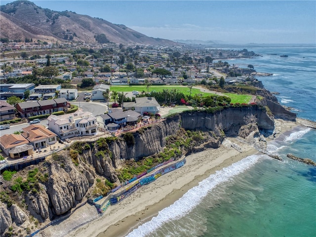 drone / aerial view featuring a beach view and a water and mountain view