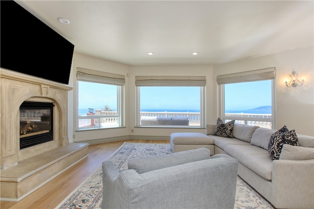 living area with light wood finished floors, a high end fireplace, and recessed lighting