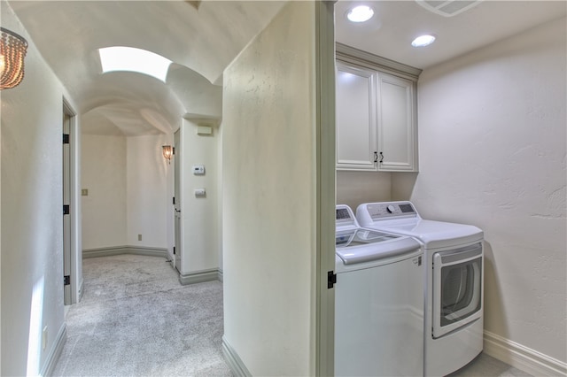 laundry room featuring light carpet, cabinet space, baseboards, a textured wall, and independent washer and dryer