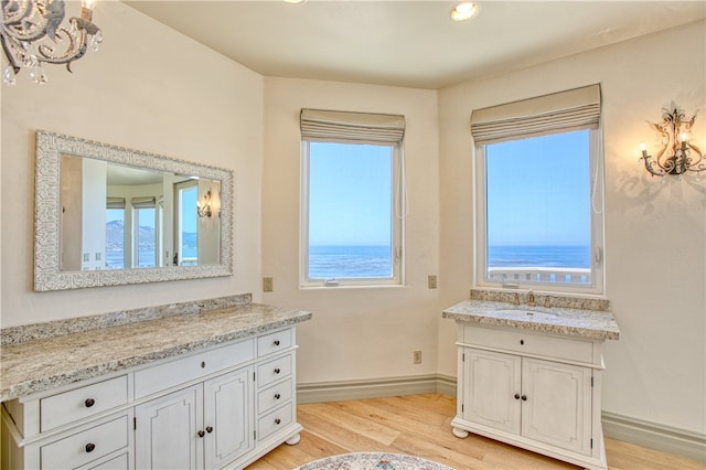 bathroom featuring a water view, baseboards, wood finished floors, and vanity