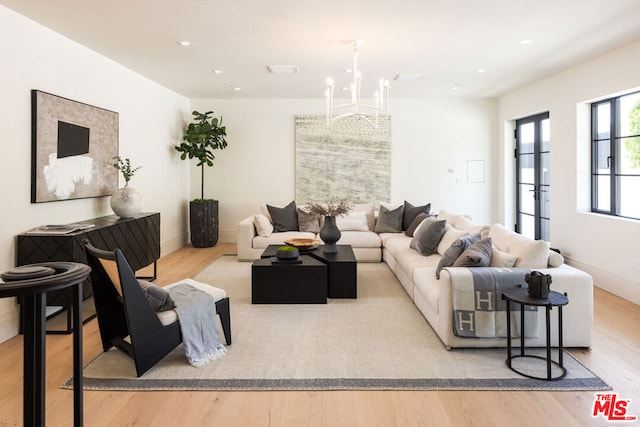 living room featuring a chandelier and light wood-type flooring