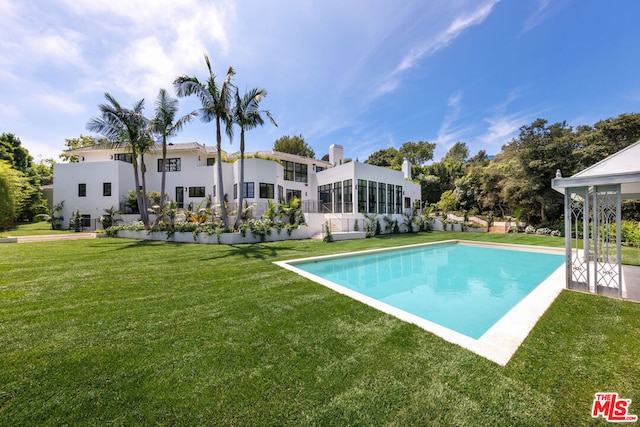 view of swimming pool with a yard