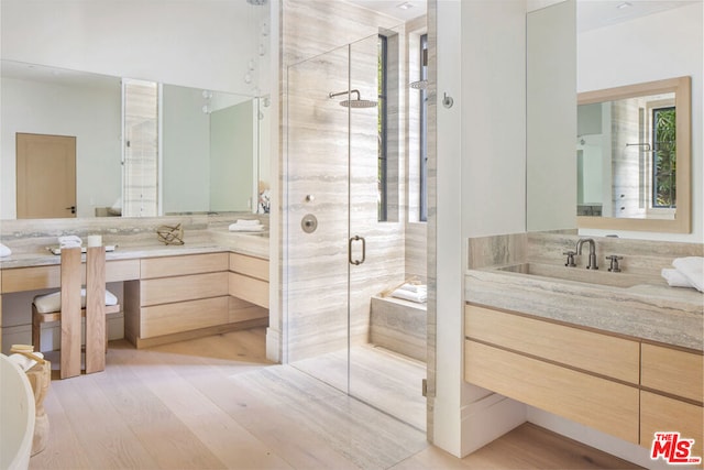 bathroom featuring wood-type flooring, vanity, and a shower with door