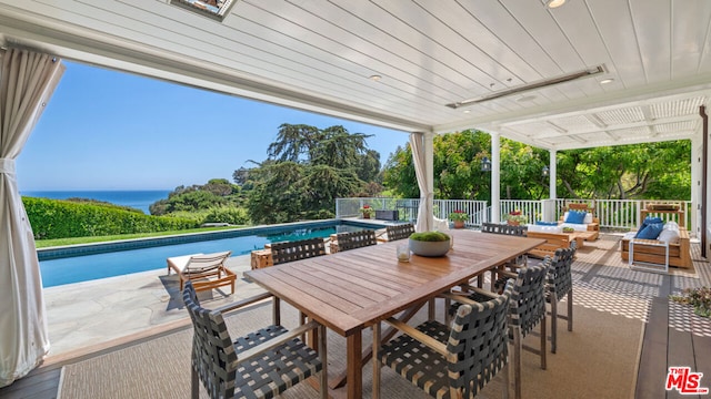 view of patio / terrace featuring an outdoor living space, a water view, and a fenced in pool