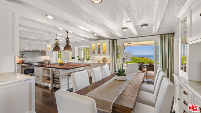 dining area featuring beam ceiling, dark hardwood / wood-style flooring, sink, and wine cooler