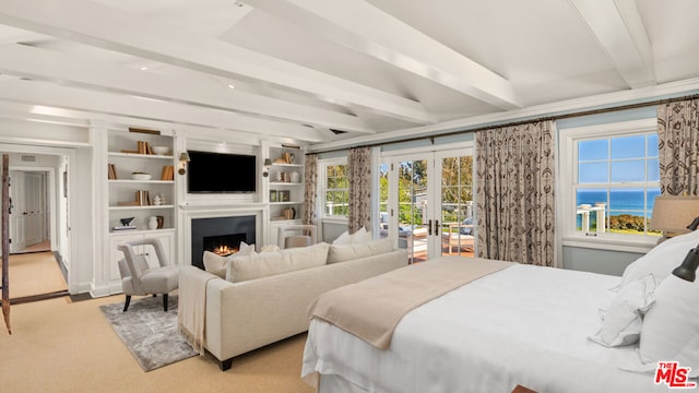 bedroom with beamed ceiling, french doors, and light carpet