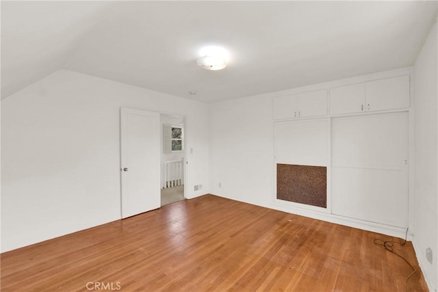 interior space featuring wood-type flooring and vaulted ceiling