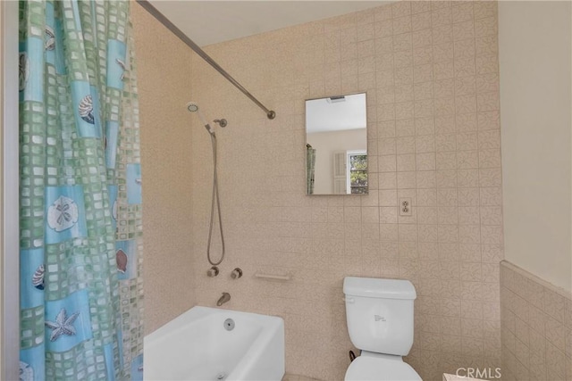 bathroom featuring shower / bathtub combination with curtain, toilet, and tile walls