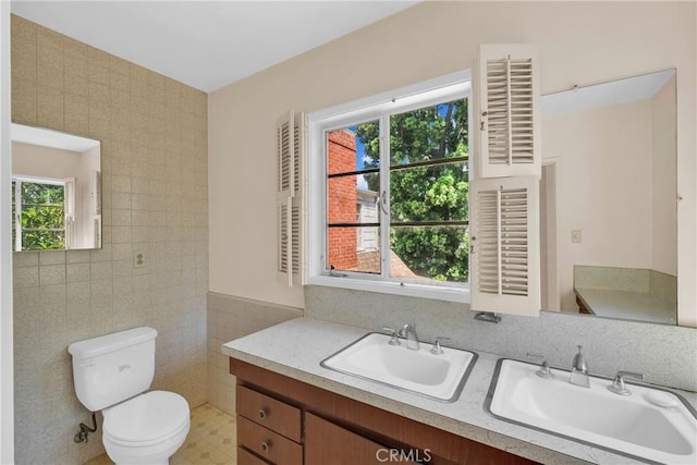 bathroom with vanity, tile walls, and toilet