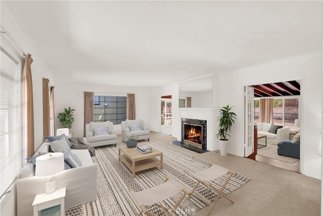 carpeted living room with a fireplace and beamed ceiling